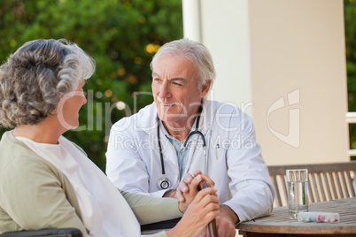 Senior doctor talking with his mature patient