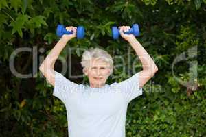 Mature woman doing her exercises in the garden