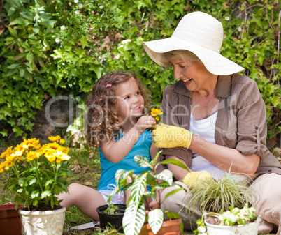 Happy Grandmother with her granddaughter working in the garden