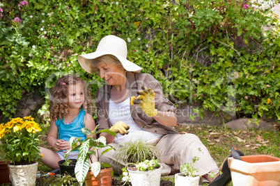 Happy Grandmother with her granddaughter working in the garden