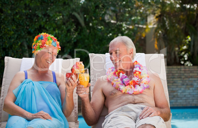 Happy senior couple drinking cocktails and toasting each other