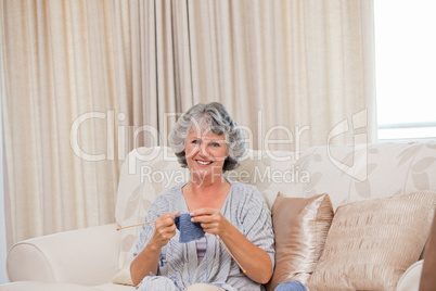 Retired woman knitting at home