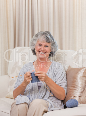 Retired woman knitting at home