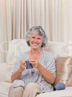 Retired woman knitting at home