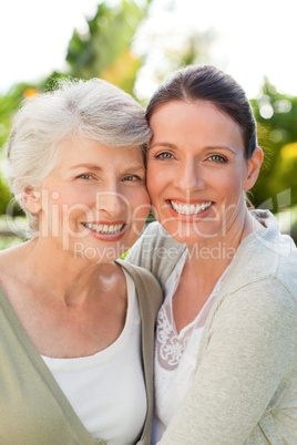 Mother with her daughter looking at the camera in the garden