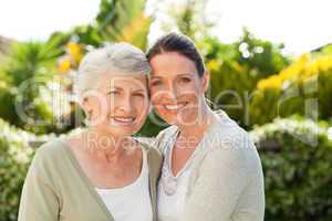 Mother with her daughter looking at the camera in the garden