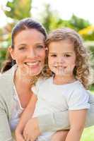 Mother with her daughter looking at the camera in the garden