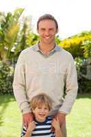 Father and his son looking at the camera in the garden