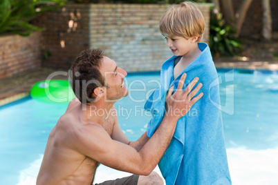 Father with his son beside the swimming pool