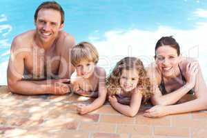 Happy family beside the swimming pool