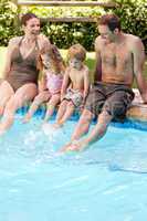 Happy family beside the swimming pool