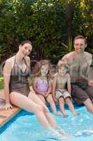 Happy family beside the swimming pool