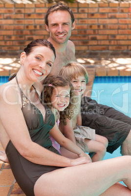 Happy family beside the swimming pool