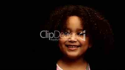 Young black girl/child with curly hair talking to camera