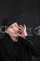 Man in black cloth and hat smoke cigar