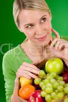 Healthy lifestyle - thoughtful woman with fruit shopping paper b