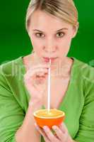 Healthy lifestyle - woman drink juice from orange with straw
