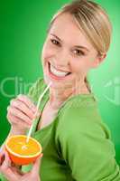 Healthy lifestyle - woman drink juice from orange with straw