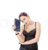 Pretty young girl in black corset with book, pen and glasses