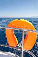 Orange lifebuoy on sailing ship