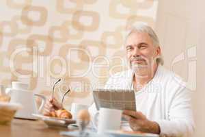 Senior mature man - breakfast at home with newspaper