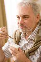 Senior mature man eat yogurt snack