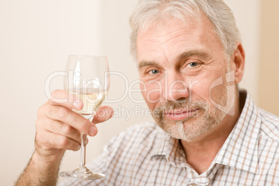 Senior mature man with glass of white wine