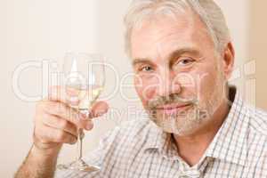 Senior mature man with glass of white wine
