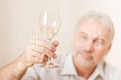Senior mature man with glass of white wine