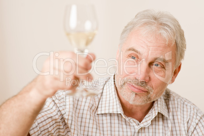 Senior mature man with glass of white wine