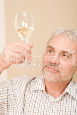 Senior mature man with glass of white wine