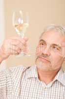 Senior mature man with glass of white wine