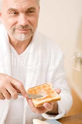 Senior mature man having breakfast toast