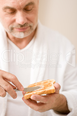 Senior mature man having breakfast toast
