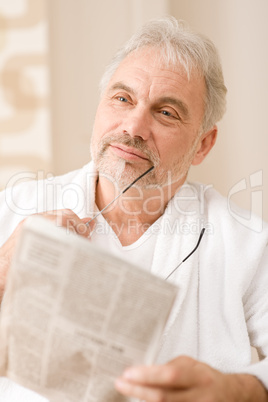 Senior mature man thoughtful read newspaper