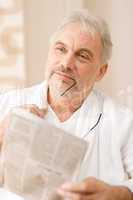 Senior mature man thoughtful read newspaper