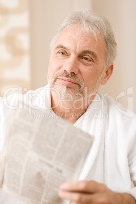 Senior mature man thoughtful read newspaper