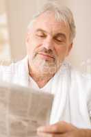 Senior mature man thoughtful read newspaper