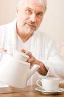 Senior mature man pour coffee wear bathrobe