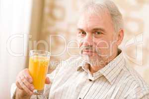Senior mature man with glass of orange juice