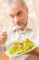 Senior mature man eat vegetable salad