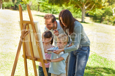 Family painting together in the park