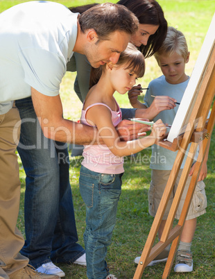 Family painting together in the park