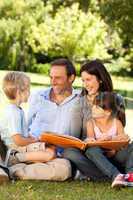 Family looking at their photo album in the park