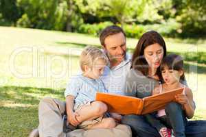 Family looking at their photo album in the park