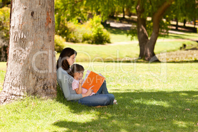 Mother with her daughter looking at their album photo