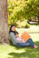 Mother with her daughter looking at their album photo