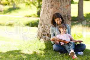 Radiant mother with her daughter looking at their album photo