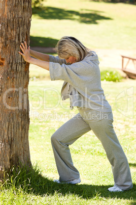 Mature woman doing her streches in the park