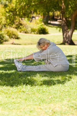 Mature woman doing her streches in the park